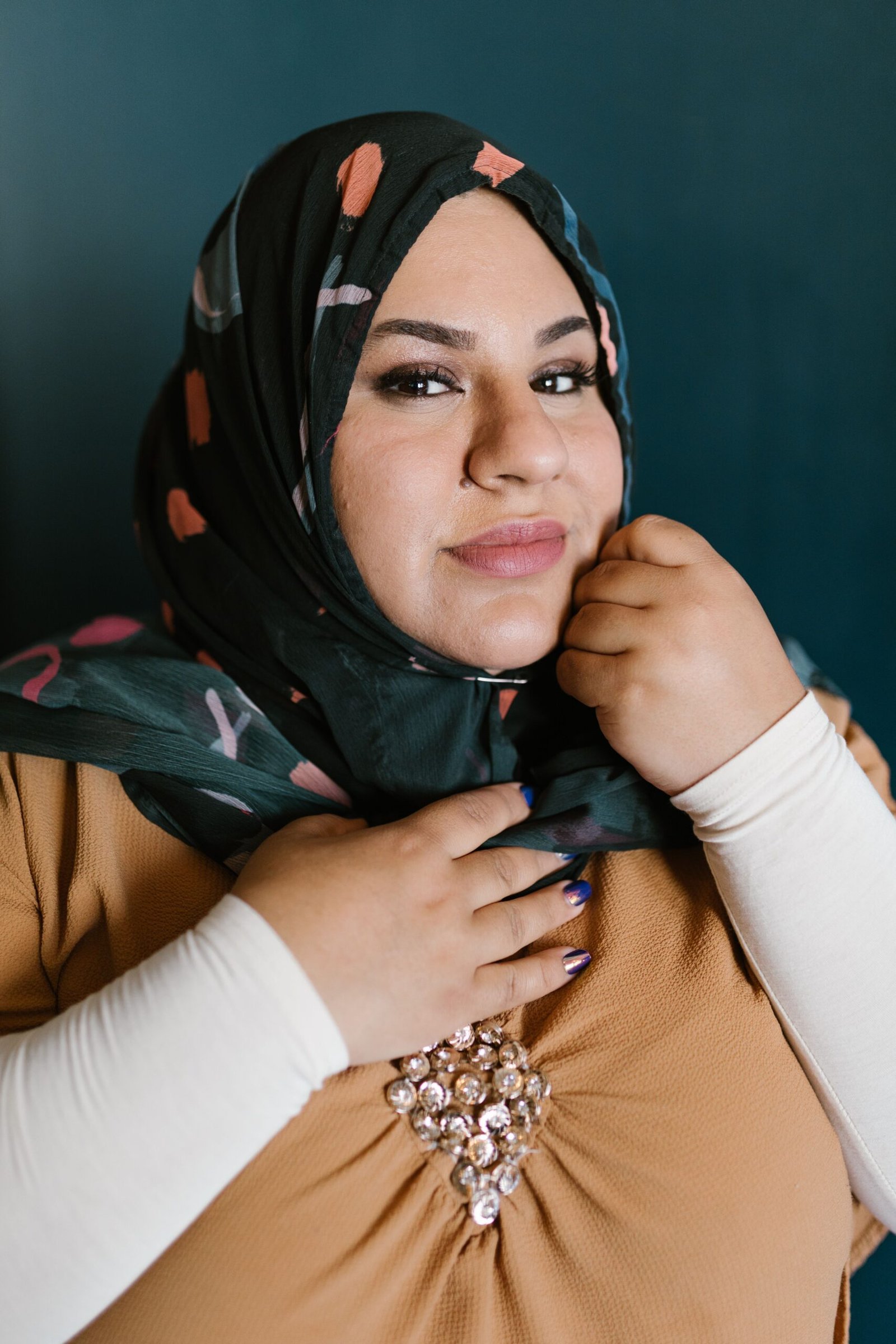 Elegant portrait of a woman in a patterned hijab showcasing confidence and style.